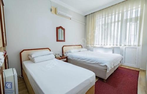 a bedroom with two beds and a window at AKÇAY LEMAN OTEL in Edremit