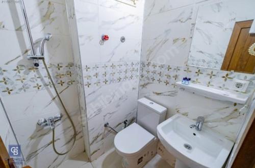 La salle de bains est pourvue de toilettes, d'une douche et d'un lavabo. dans l'établissement AKÇAY LEMAN OTEL, à Edremit