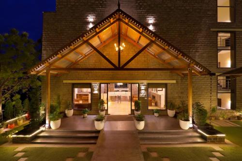 a building with potted plants in front of it at Lemon Tree Hotel, Kasauli in Kasauli