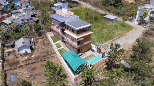 een uitzicht op een huis met een groen dak bij JK Resort in Yercaud