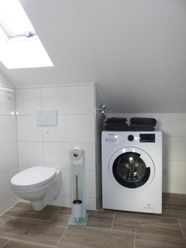 uma casa de banho com uma máquina de lavar roupa e um WC em Alb-Biosphäre-Ferienwohnung em Ingstetten