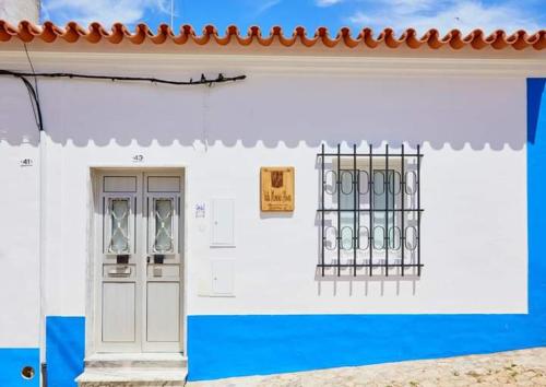 a white and blue building with a door and window at Vale Moreno House in Reguengos de Monsaraz