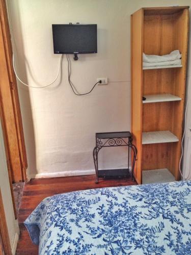a bedroom with a bed and a tv on the wall at Tralkan B&B in Santiago