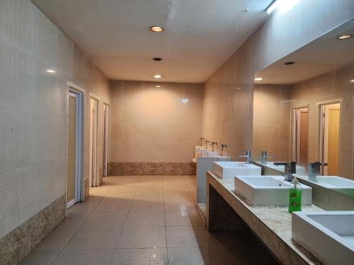 a large bathroom with three sinks and two mirrors at Regalia Serviced Suites KLCC Infinitypool in Kuala Lumpur
