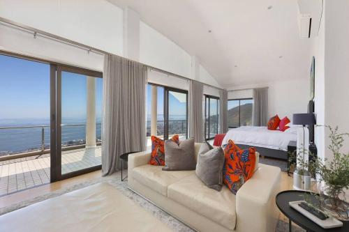 a bedroom with a bed and a couch with a view at Exclusive Bantry Bay Villa in Cape Town