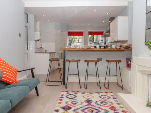 eine Küche und ein Wohnzimmer mit einer Theke und Stühlen in der Unterkunft Midhurst in Brixham