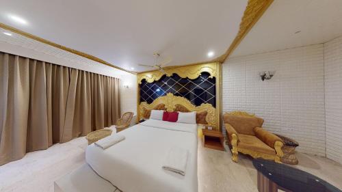 1 dormitorio con 1 cama grande y 1 sofá en HOTEL VIJAYARANI, en Tiruchchirāppalli