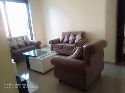 a living room with two couches and a coffee table at VILLA FIORI APARTMENTS in Arua