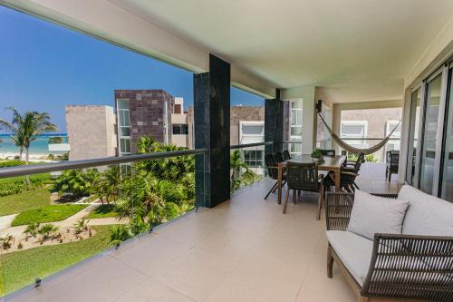 a balcony with a table and chairs and a view of the ocean at Mareazul Beach Front Condos At playa del Carmen in Playa del Carmen
