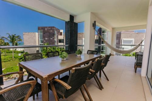 a dining room with a table and chairs on a balcony at Mareazul Beach Front Condos At playa del Carmen in Playa del Carmen