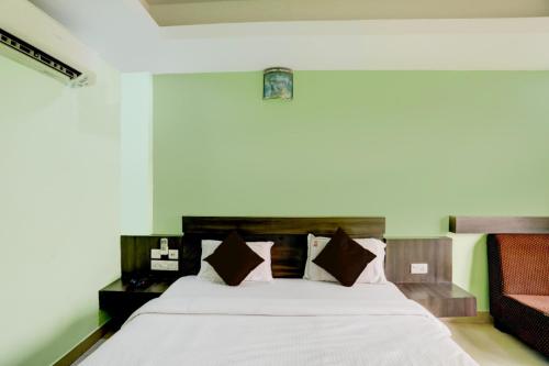 ein Schlafzimmer mit einem großen weißen Bett mit braunen Kissen in der Unterkunft Hotel Deep Ganga Inn Puri Sea View Room in Puri