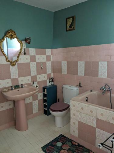 une salle de bain avec un lavabo, une baignoire et des toilettes dans l'établissement Le Clos des oliviers, à Rieux-en-Val