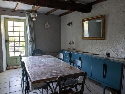 uma sala de jantar com uma mesa e armários azuis em Le Clos des oliviers em Rieux-en-Val