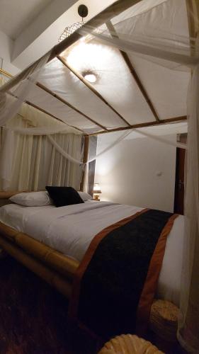 ein großes Bett in einem Zimmer mit in der Unterkunft Ariwigangga Guest House in Krambitan