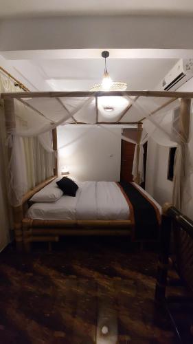 ein Schlafzimmer mit einem Etagenbett mit einer Decke in der Unterkunft Ariwigangga Guest House in Krambitan