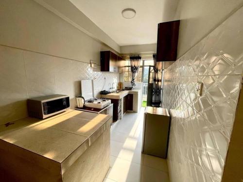 a kitchen with a stove and a microwave at B&M homes, ensuite 2 bedrooms Meru in Meru