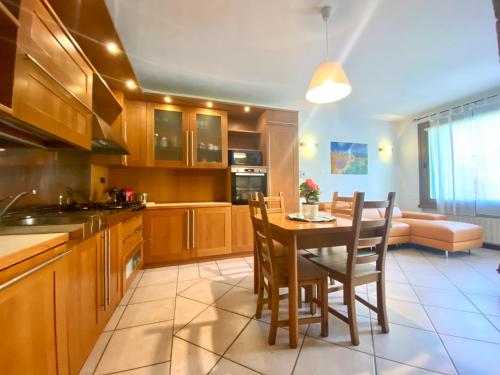 a kitchen with a table and chairs and a couch at CASA VACANZA Residence Lago di Endine in Monasterolo del Castello