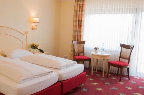 a hotel room with two beds and a table and chairs at Gasthaus Weingut Stahl in Oberwesel