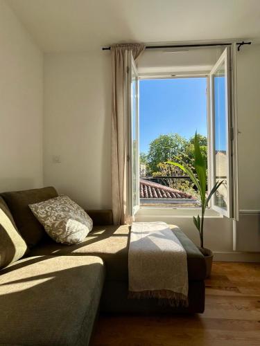 un salon avec un canapé et une fenêtre dans l'établissement Appartement Bordeaux centre, à Bordeaux