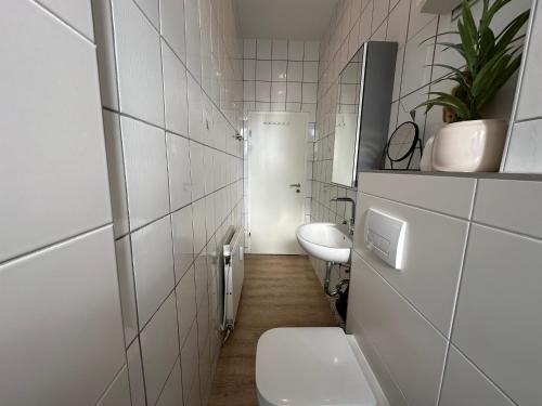 a bathroom with two sinks and a toilet in it at SHINY HOMES - Bielefeld Mitte in Bielefeld