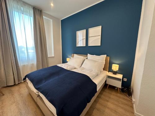 a blue bedroom with a bed with a blue wall at SHINY HOMES - Bielefeld Mitte in Bielefeld