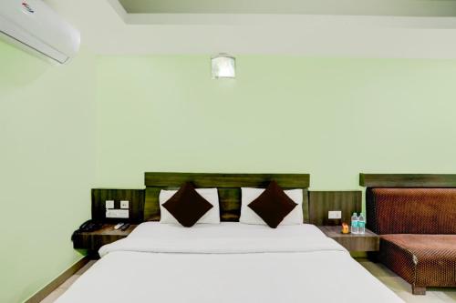 een slaapkamer met een groot wit bed en een bank bij Goroomgo Deep Ganga Inn Near Sea Beach Puri in Puri
