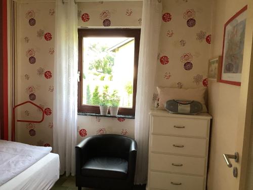 a bedroom with a chair and a window at Land und Leute - Landleben Fewo 1 in Fritzlar