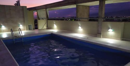 a swimming pool with a view of the city at night at Alquiler Temporario Tucumán Con Cochera Y Pileta in San Miguel de Tucumán