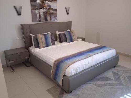 a bedroom with a bed with blue pillows at as sifah in Muscat
