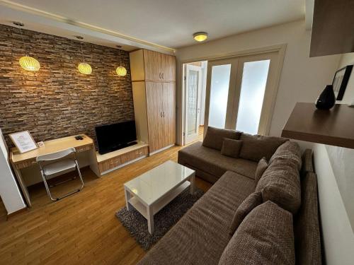 a living room with a couch and a tv at Nevena Belville Apartments in Belgrade