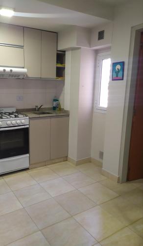 an empty kitchen with a stove and a window at Alquiler Temporario Tucumán Con Cochera Y Pileta in San Miguel de Tucumán