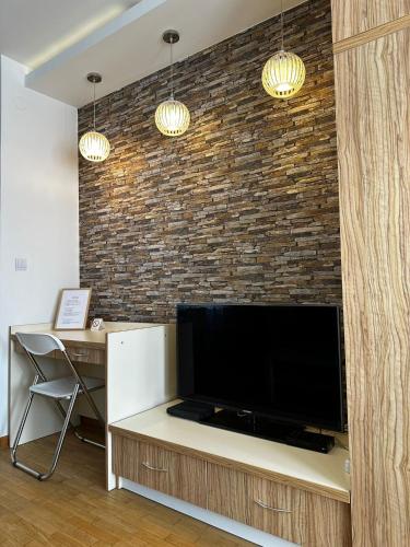 a living room with a large flat screen tv on a brick wall at Nevena Belville Apartments in Belgrade