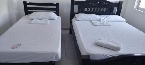 two beds sitting next to each other in a room at Hotel Río Mar in Cartagena de Indias