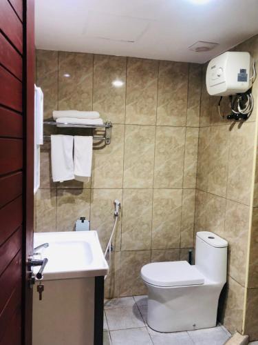 La salle de bains est pourvue de toilettes et d'un lavabo. dans l'établissement Fashion International Hotel, à Dar es Salaam