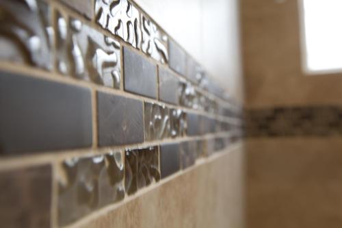 a row of tiles on a wall in a bathroom at Dunes Inn - Sunset in Los Angeles