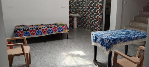 a room with two beds and a table and chairs at happy khajuraho home stay in Khajurāho