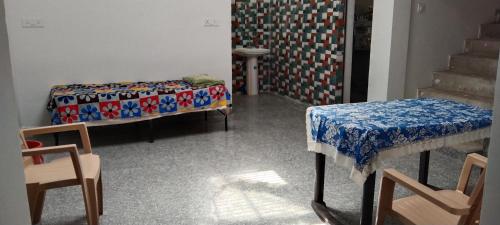 een kamer met 2 bedden en een tafel en stoelen bij happy khajuraho home stay in Khajurāho