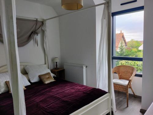 - une chambre avec un lit à baldaquin et une fenêtre dans l'établissement RARE à Cabourg - Maison neuve avec piscine et jardin, à Cabourg