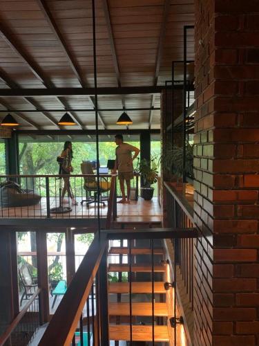 dos personas de pie en un balcón de una casa en Kay’s Den Kandy, en Peradeniya