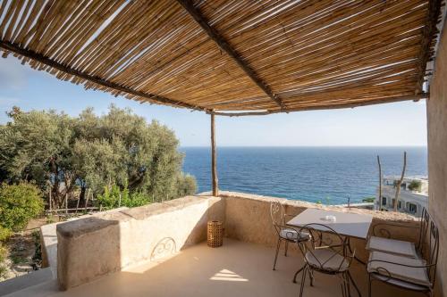 Un patio con mesa y sillas y el mar. en Alma Domus ancient house recently opened, en Amalfi