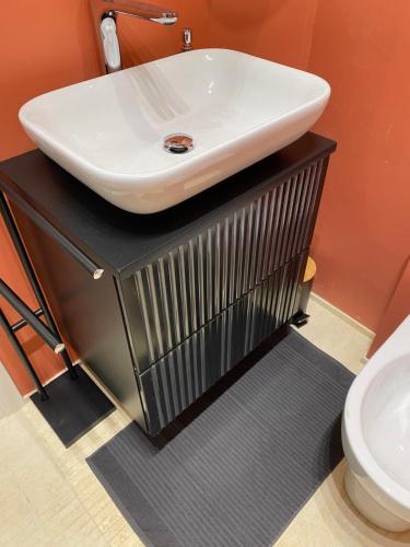 a bathroom with a white sink on a black counter at Al FRONTE MARE SUITES APARTMENTS in Muggia