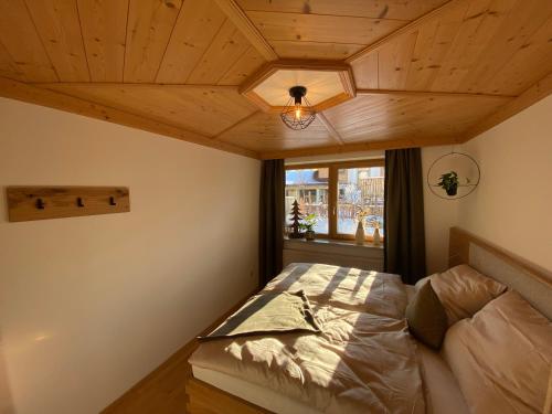 1 dormitorio con cama y ventana en Appartement Kollingwald, en Saalfelden am Steinernen Meer