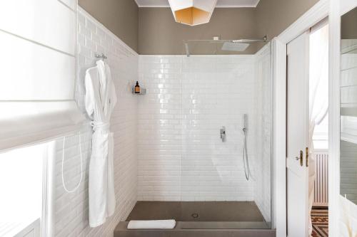 a bathroom with a shower with white tiles at Seven Rooms Villadorata in Noto