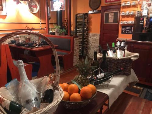 un bar con una cesta de naranjas y botellas de vino en Blue House Apartman Kék Ház Üdülő, en Dunapataj