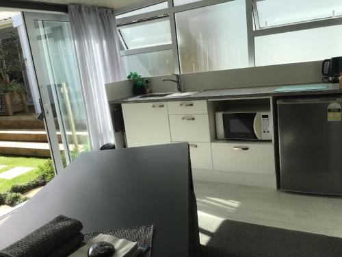 a kitchen with a table and a counter top at Tranquil Garden Studio in Tauranga