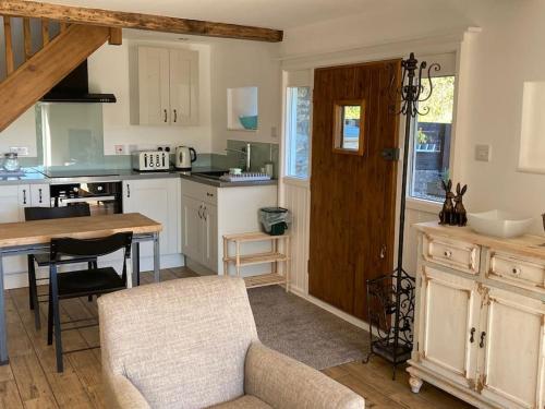 a kitchen with a table and chairs and a wooden door at The Barn at Tanlake in Buckland St Mary