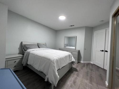a white bedroom with a bed and a television at Entire 3 BR & 2 BA house for business and family in Modesto