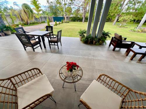 un patio con sillas, mesas y una mesa con flores en Summerfields & Gardens Lodge, en Kitwe