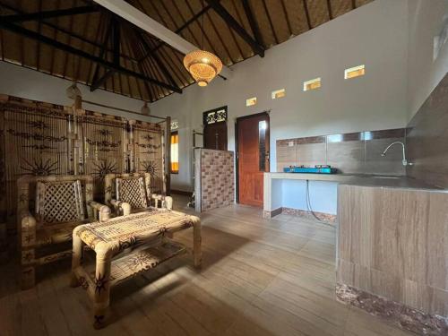 ein Wohnzimmer mit einem Sofa und einer Küche in der Unterkunft Ariwigangga Garden Guest House in Krambitan