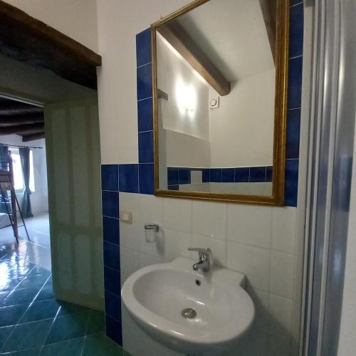 a bathroom with a sink and a mirror at La Locanda del Curato Rooms in Lentiscosa